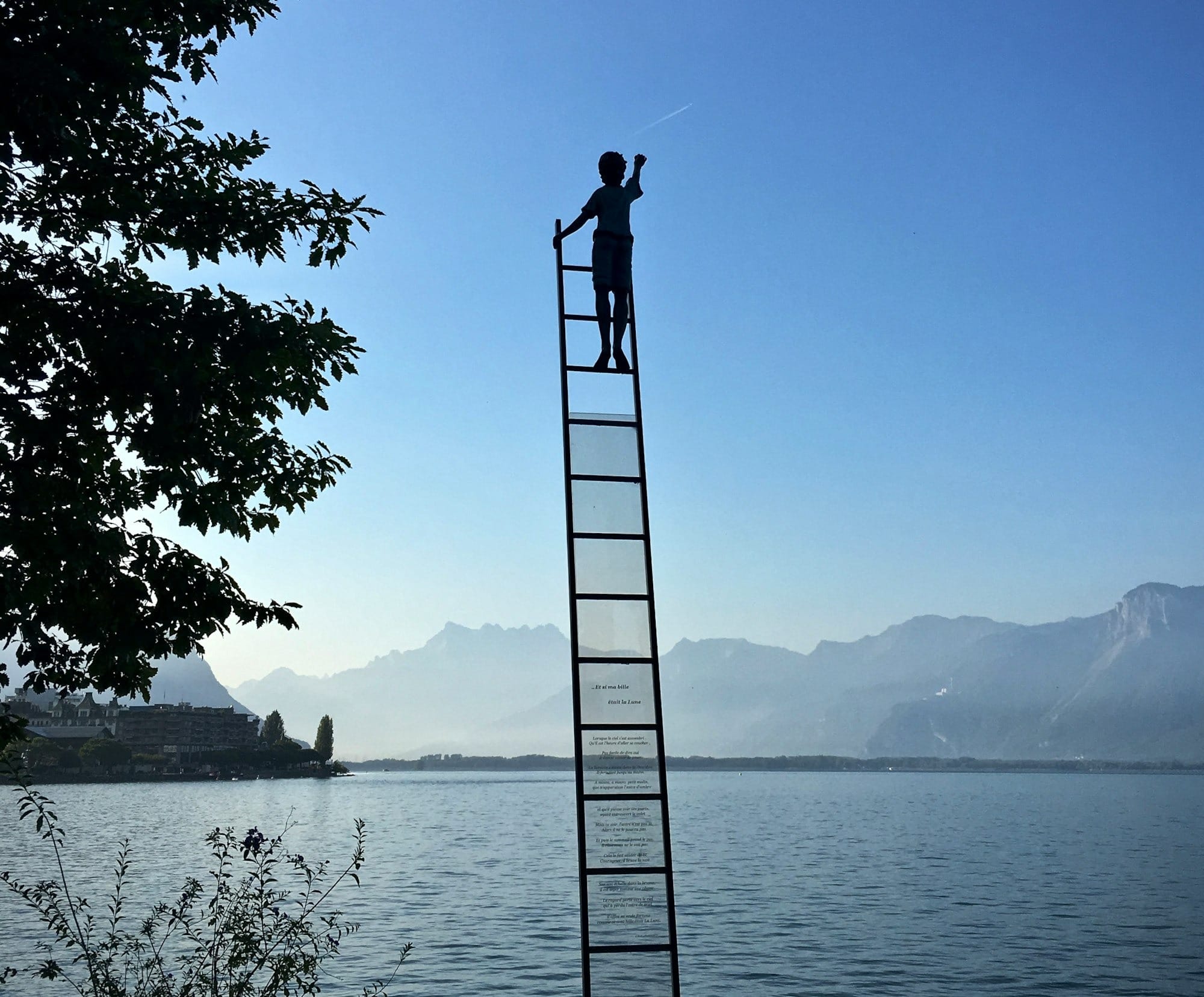 boy on ladder under blue sky