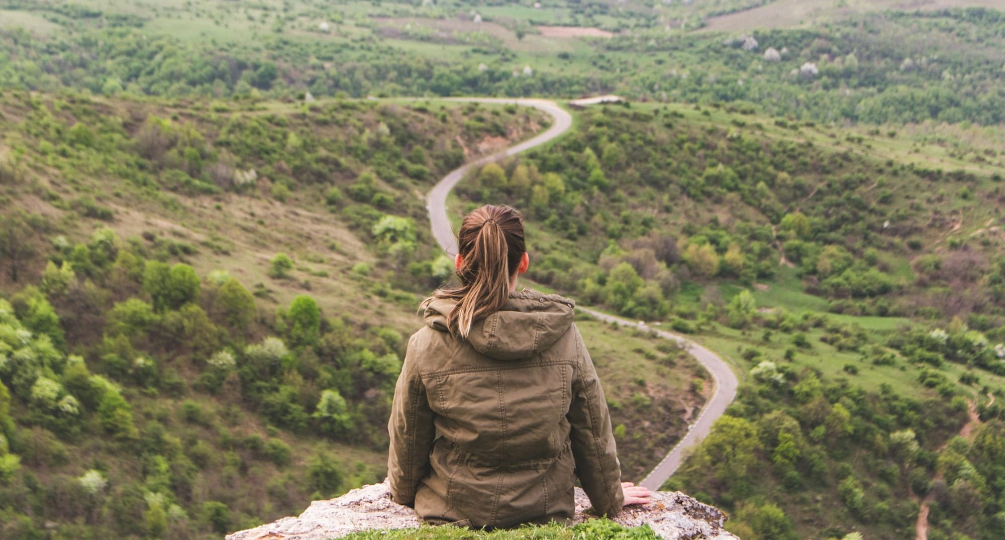 woman sitting on grey cliff