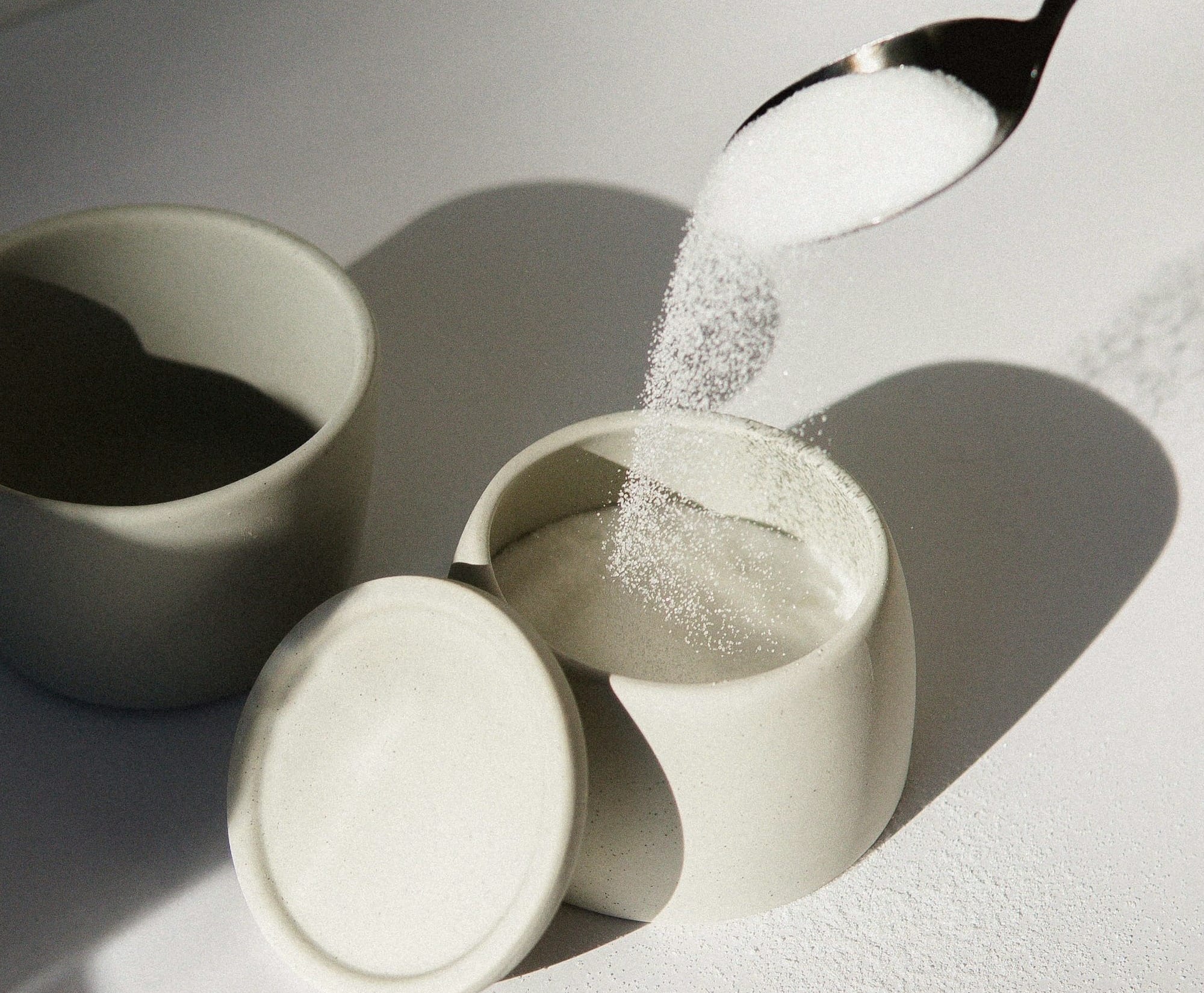 white ceramic mugs on white table